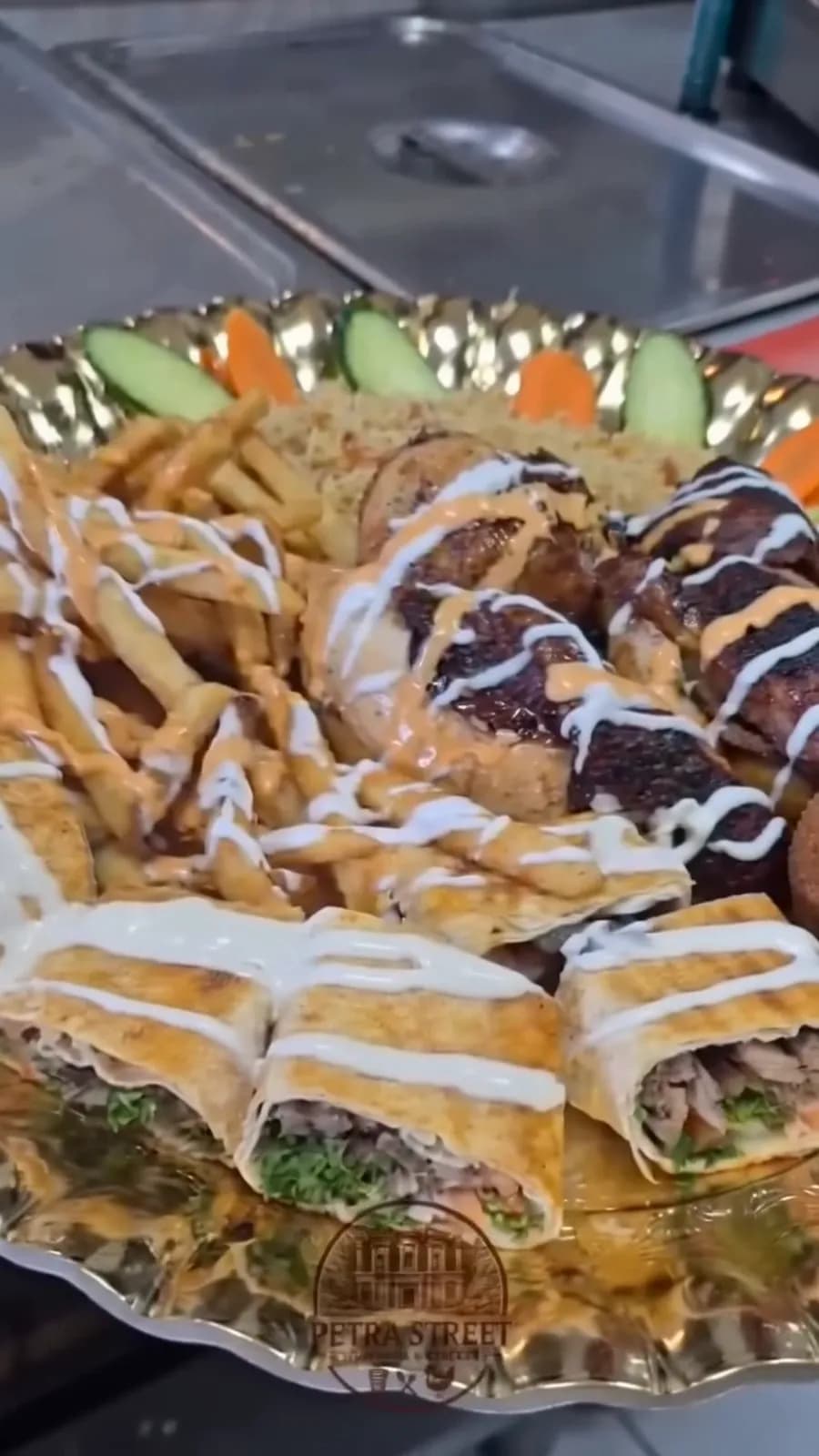 A shared platter — shawarma wraps, falafel, kebab and fries with garlic and tahini sauces